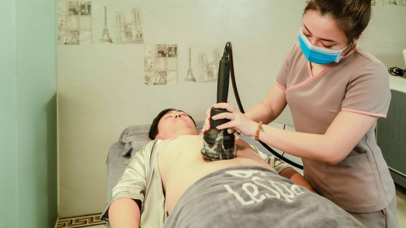 Un thérapeute de spa réalise un traitement de remodelage corporel sur un patient à Hanoi, Vietnam.