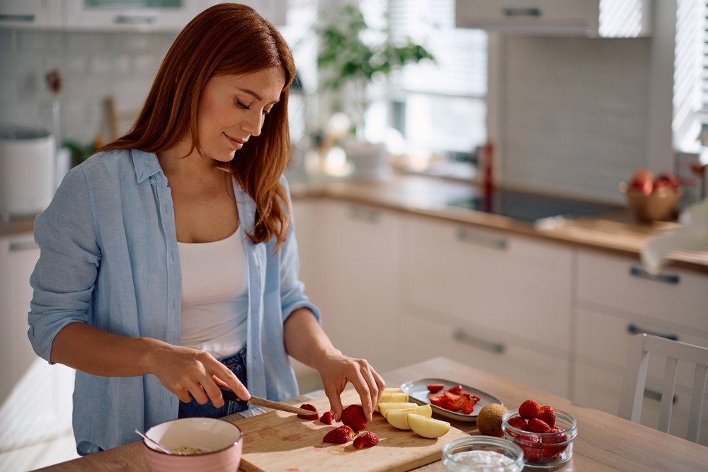 Femme qui coupe des fruits